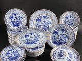 a group of blue and white plates and cups on a black surface