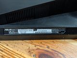 a close up of a black laptop on a wooden table