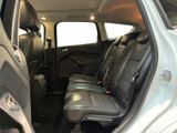 the back seats of a silver car with a black seat belt