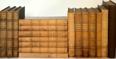 several old books are lined up on a shelf next to each other