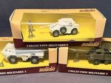 three boxed toys of military vehicles in boxes on a gray surface