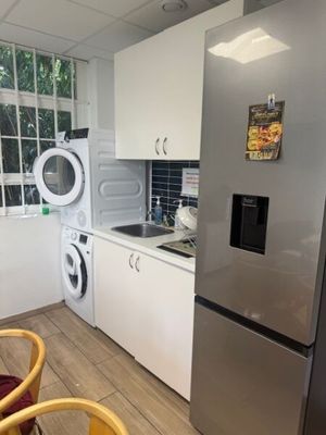 a kitchen with a refrigerator, washing machine, and a washing machine