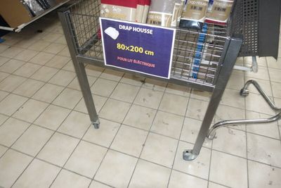 un caddie sur lequel est accrochée une affiche, dans un magasin