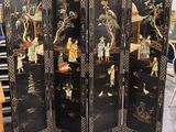 une image représentant un paravent noir orné de motifs asiatiques