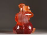 a red gummy bear sitting on a white surface