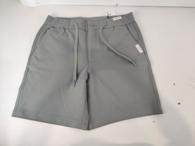Le short est gris et comporte une étiquette blanche sur le côté.