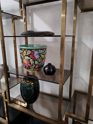 une étagère en verre sur laquelle sont posés des vases, dans une pièce