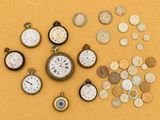 de nombreux types d'horloges et de pièces de monnaie sur la table
