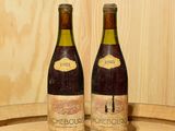 deux bouteilles de vin posées sur un tonneau