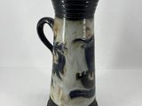 un vase noir et blanc sur lequel est représenté un visage
