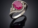 une bague en tourmaline rose et diamants posée sur un fond noir