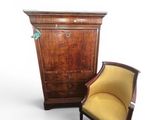 a chair and a chest of drawers next to each other