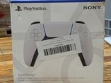 La boîte de la manette PlayStation est posée sur la table.
