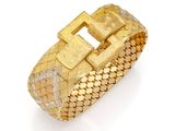 a close up of a gold bracelet on a white background