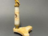 a small ivory figurine on a wooden stand with a figurine on top of it