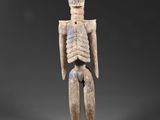 une figurine en bois représentant un squelette avec une grosse tête et des bras