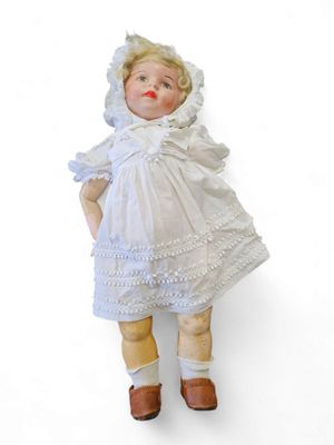 a doll that is wearing a white dress and hat