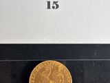 a close up of a gold coin on a black surface