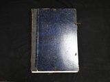 a small blue book on a black cloth