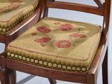 pair of antique wooden chairs with floral upholstered seat cushions