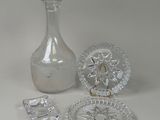 a glass bottle, a glass plate, and a glass plate on a table