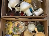 two boxes full of cups and saucers sitting on the floor