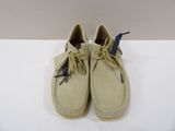 pair of men ' s tan sued boat shoes on a white surface