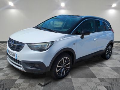 une Opel blanche garée dans une pièce au sol à carreaux