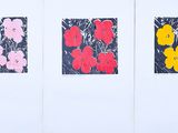 three prints of flowers are displayed on a white wall