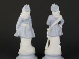 pair of porcelain figurines of a man and a woman dressed in blue and white