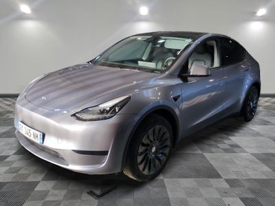 the silver tesla suv is parked on a checkered tile floor