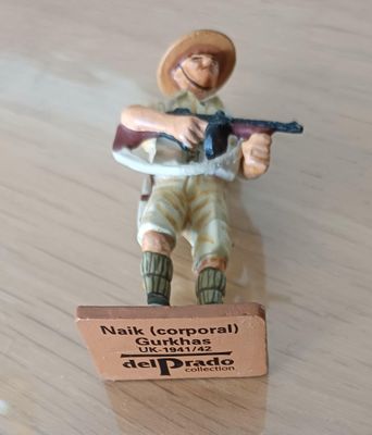 figurine représentant un homme armé, posée sur une table en bois