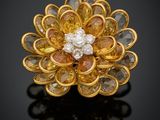 une broche en forme de fleur en diamants jaunes et blancs sur un fond noir