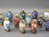 sept vases ornés de motifs variés, posés sur un fond gris