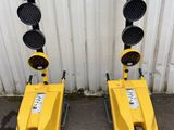 two yellow traffic lights sitting next to each other on the side of a building