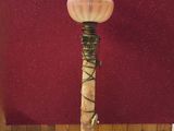 lampe en laiton et marbre posée sur un socle, avec un mur rouge en arrière-plan