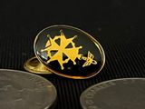 a black and gold ring sitting on top of a coin