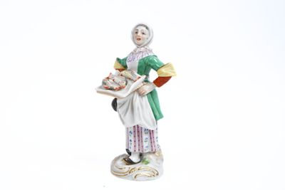 une figurine représentant une femme tenant un plateau avec de la nourriture