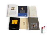 five books that are sitting on a white surface