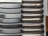 six knives and a knife holder on a table