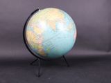 an image of a small globe on a stand against a black background