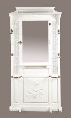 une photo d'une armoire blanche surmontée d'un miroir