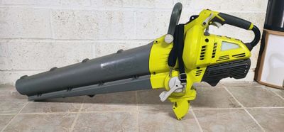 a yellow and black blower sitting on a tiled floor next to a brick wall