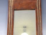 un petit miroir accroché au mur au-dessus d'une lampe
