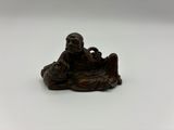 une petite statue représentant un homme assis sur une table