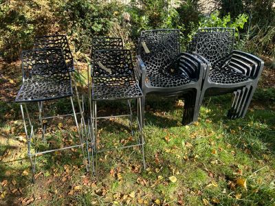 quatre chaises et une table posées dans l'herbe, devant des arbres