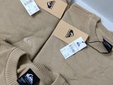 two men ' s sweaters with tags on them sitting on a table