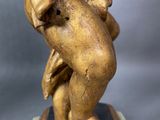 an image of a statue of a man holding a baby on a base
