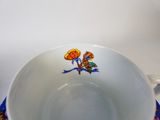a cup with a butterfly on it sitting on a saucer