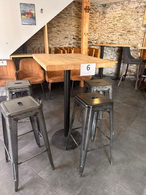 des tables et des tabourets dans un restaurant aux murs et aux escaliers en pierre